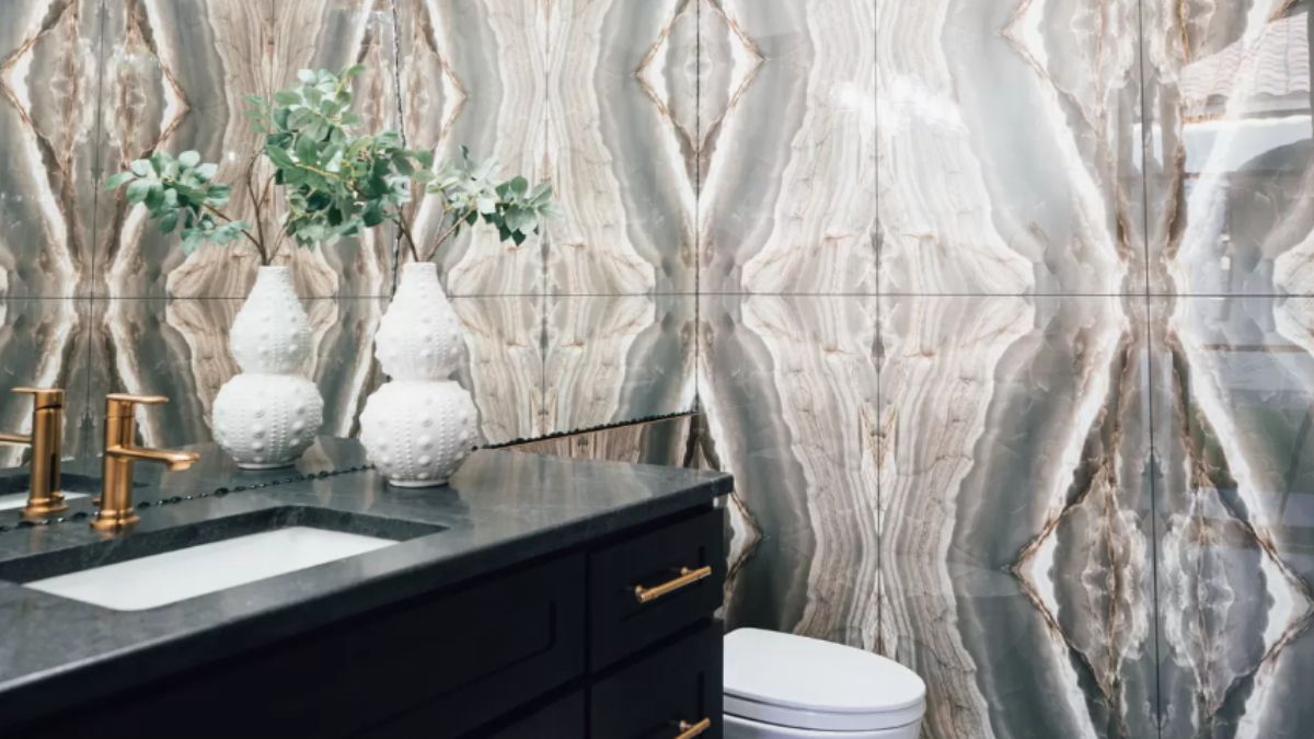 A bathroom with tiled walls, a vanity, and a toilet.