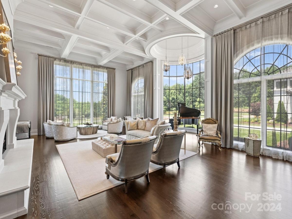 Living room with hardwood flooring, glass windows and coffered ceiling.