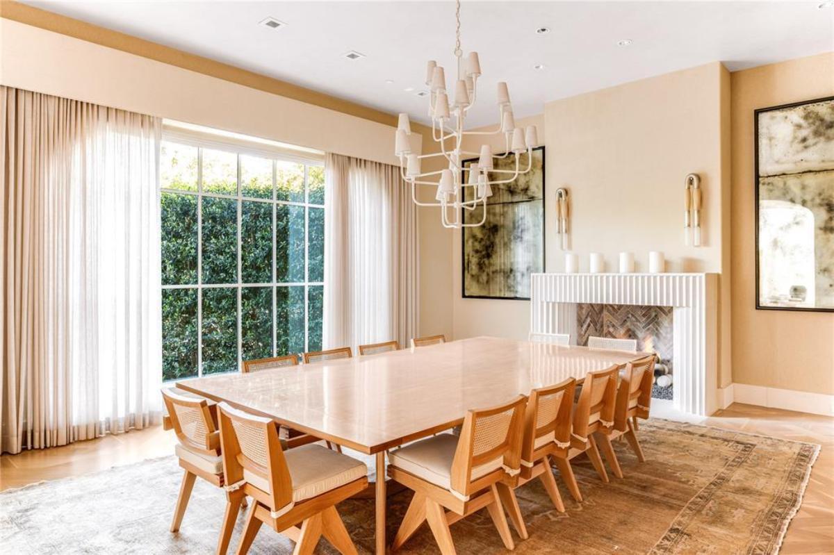 Dining room with a fireplace and glass windows.