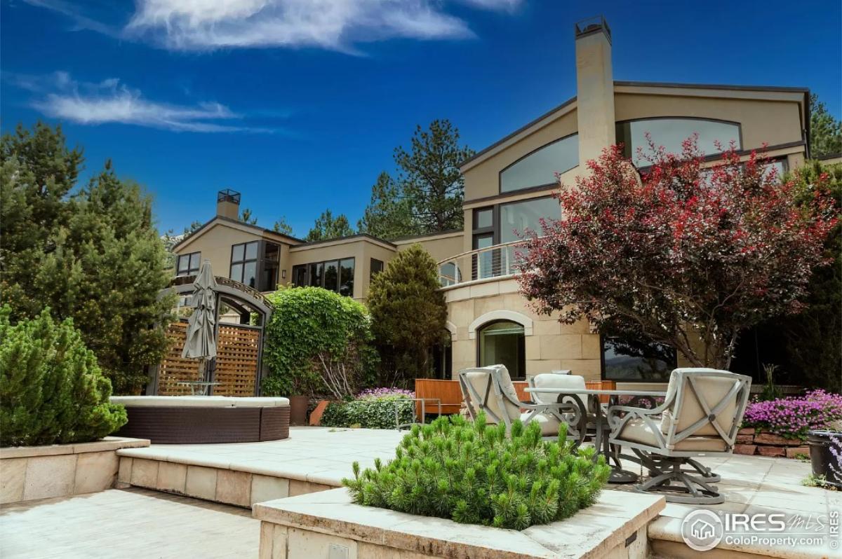 Backyard of the mansion with a patio and an In-ground hot tub.