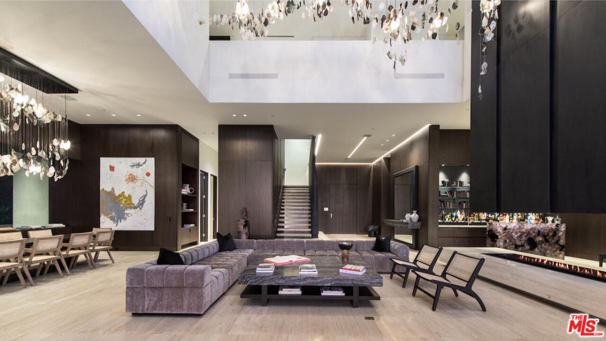 Living room with couches, a fireplace and chandeliers.