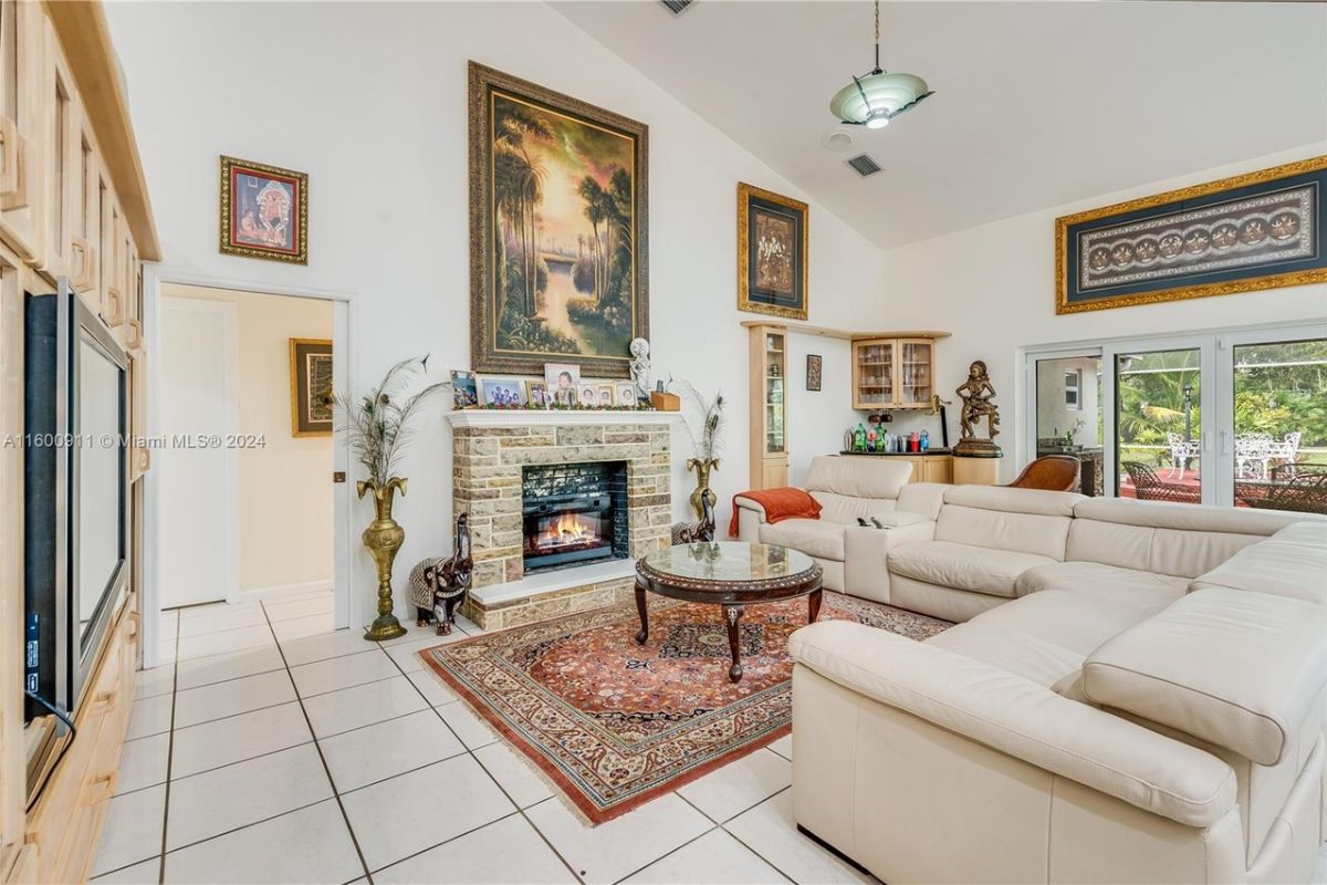 A living room with a painting, fireplace, rug, couches, and a center table.