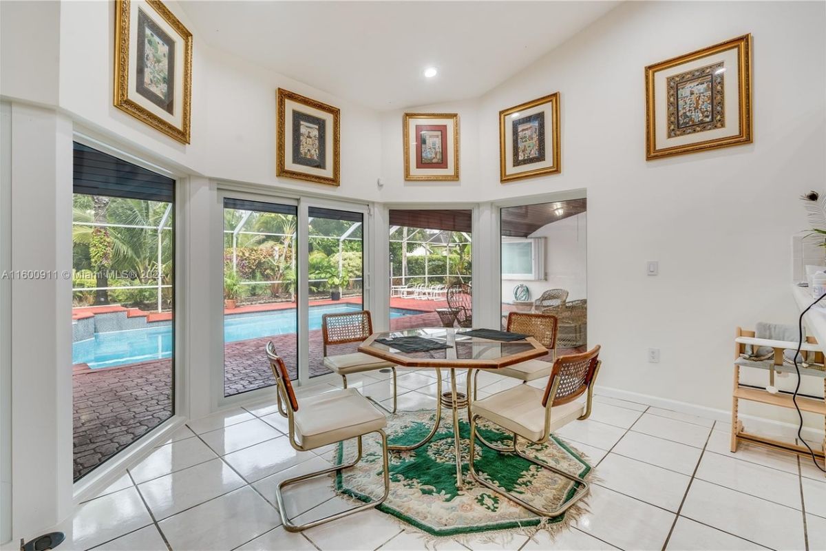 A breakfast nook with tiled floor, a rug, and a table surrounded by chairs.