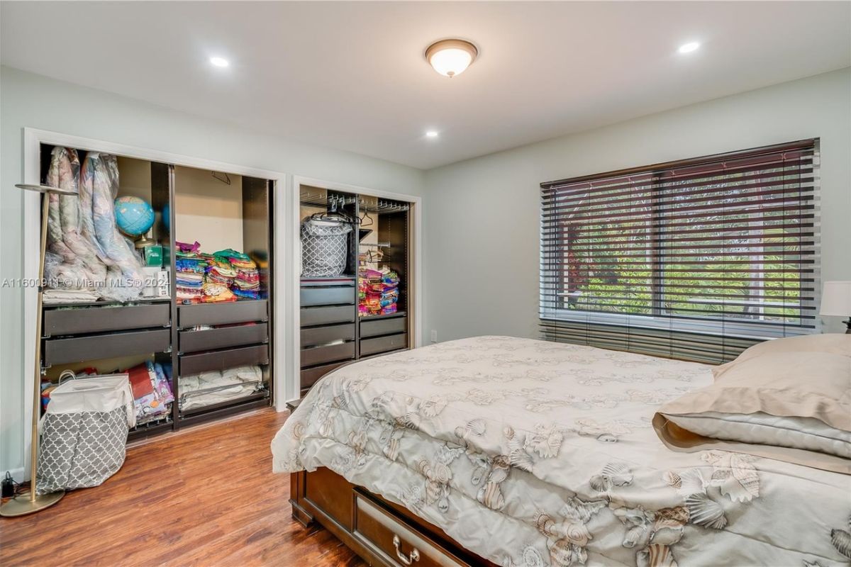 A bedroom with a bed, window, and closet.