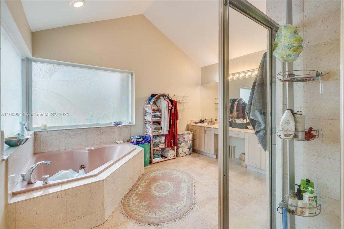 A bathroom with tiled floor, window, and bathtub.