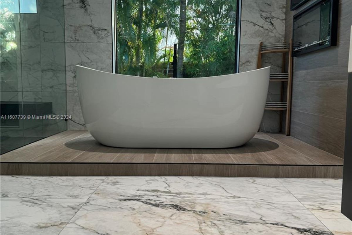 A bathroom with tiled floor and a window.