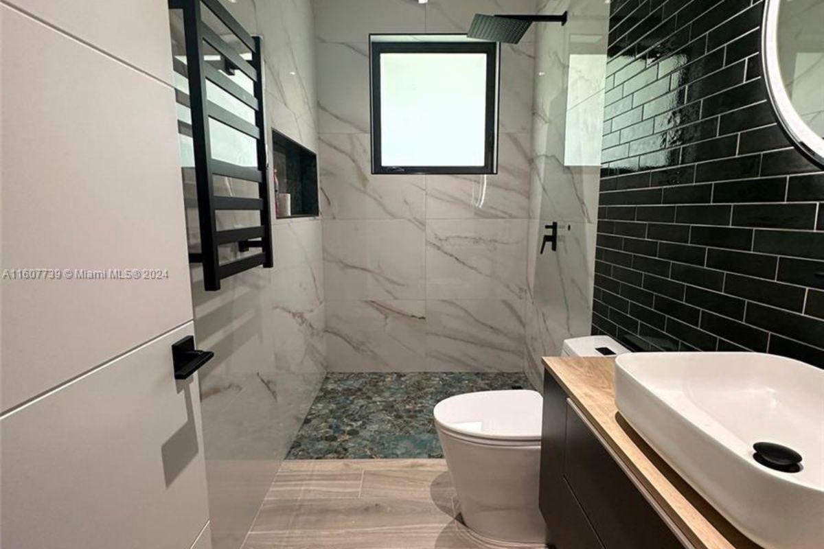 A bathroom with a bathtub, toilet, and shower room.