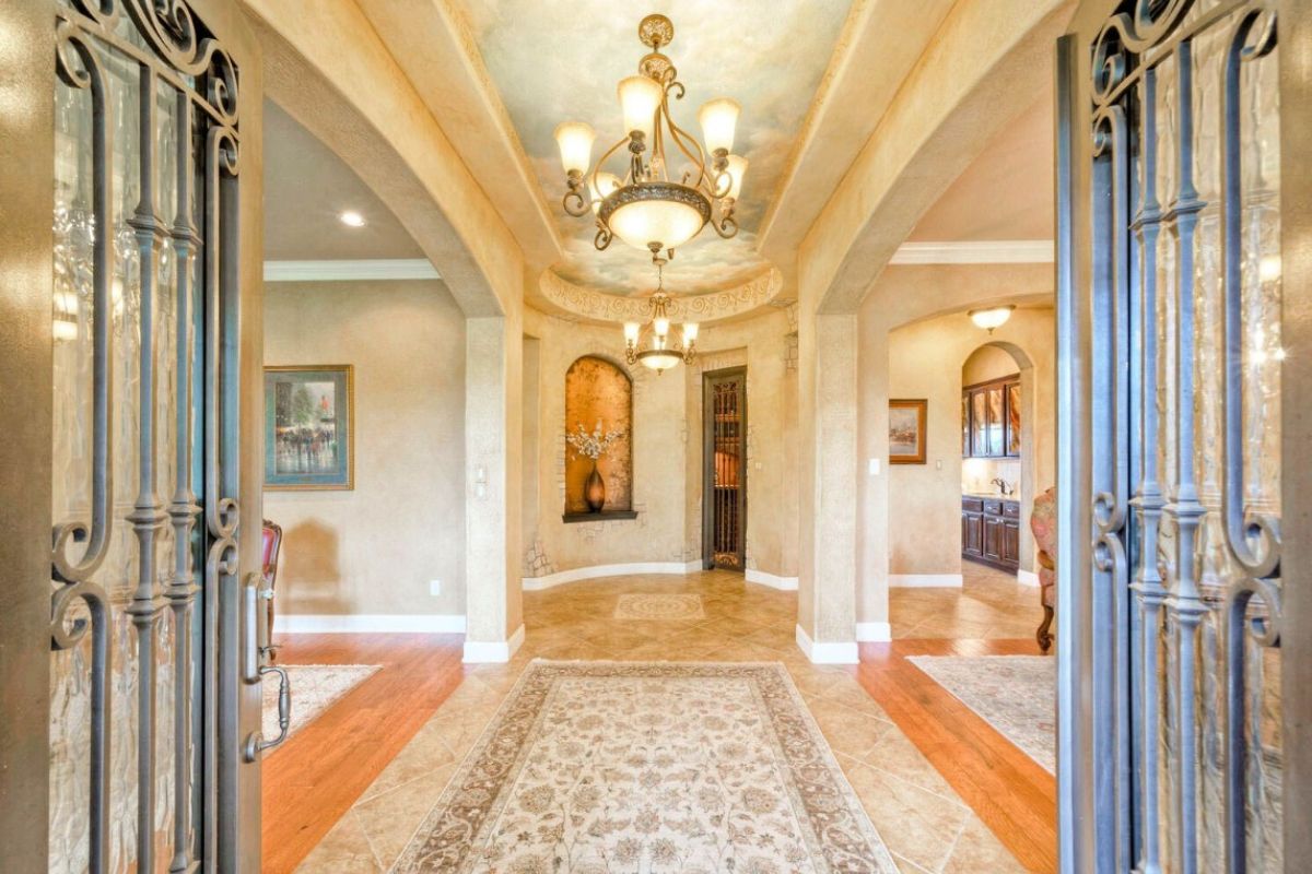 A foyer with a rug and chandelier.