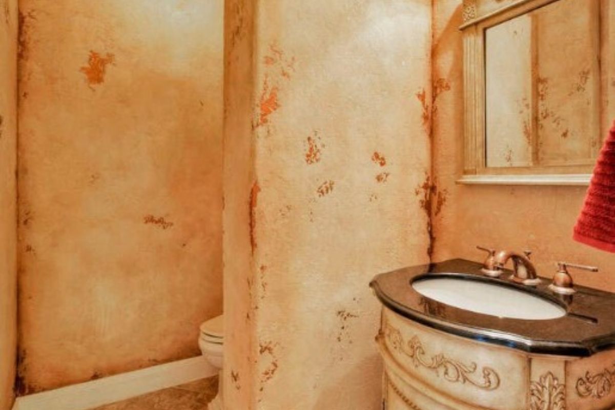 A bathroom with a vanity, mirror, and toilet.