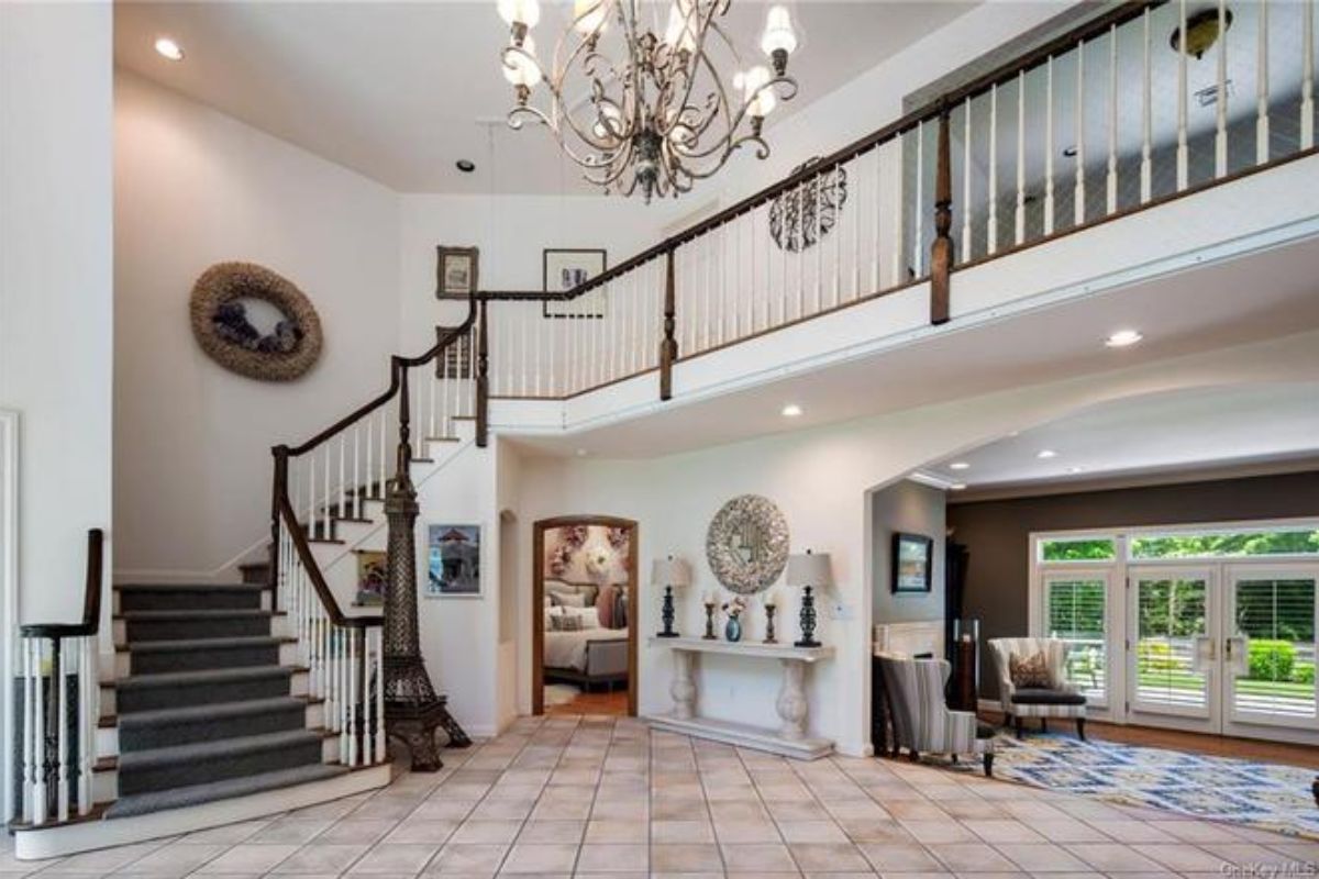 A foyer with tiled floor, chandelier, and staircase.