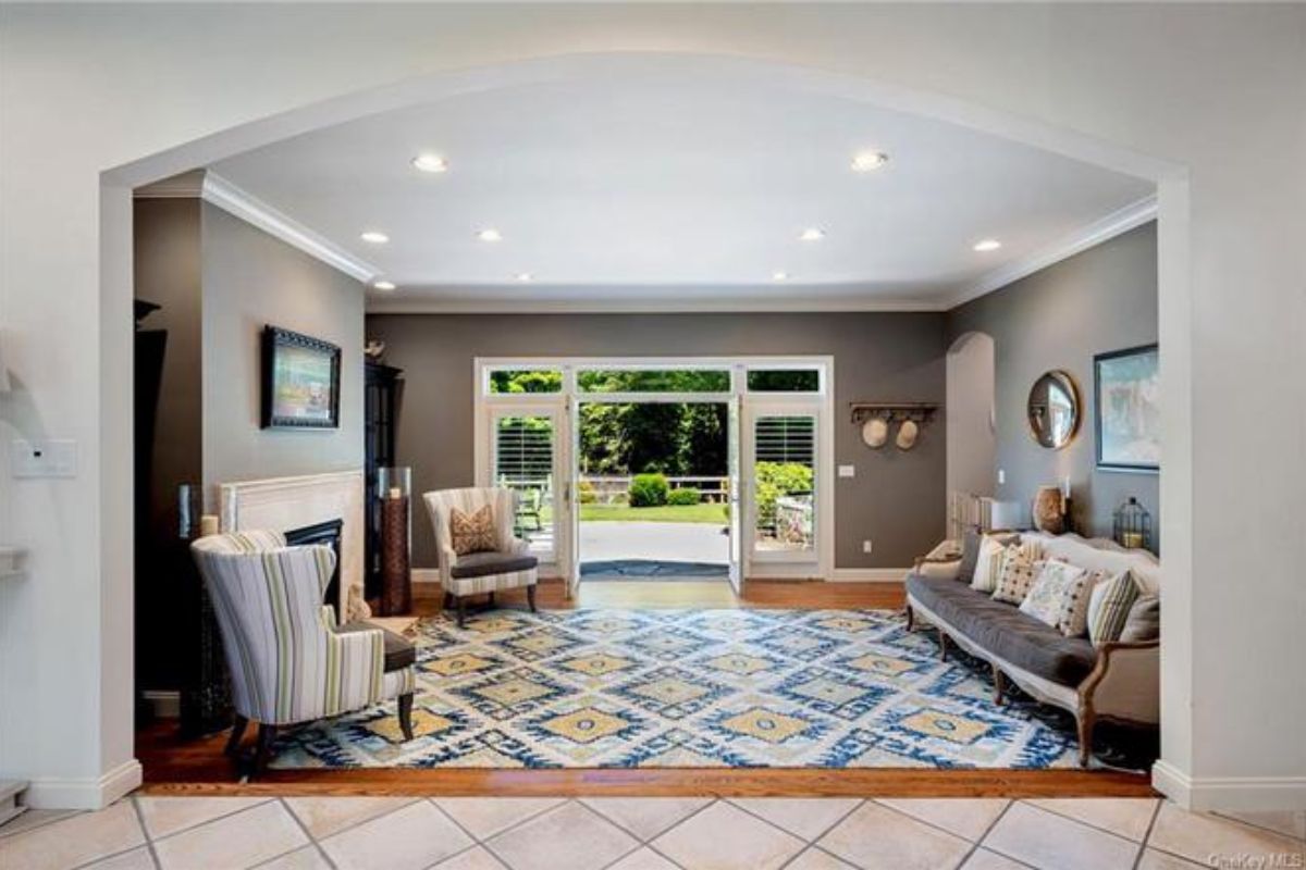 A living room with a fireplace, couch, and chairs.