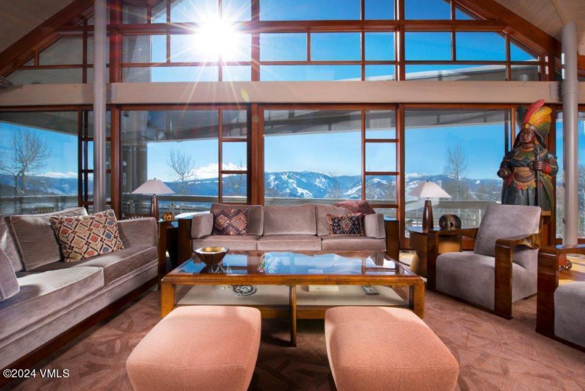 Living room with couches and floor-to-ceiling glass windows.