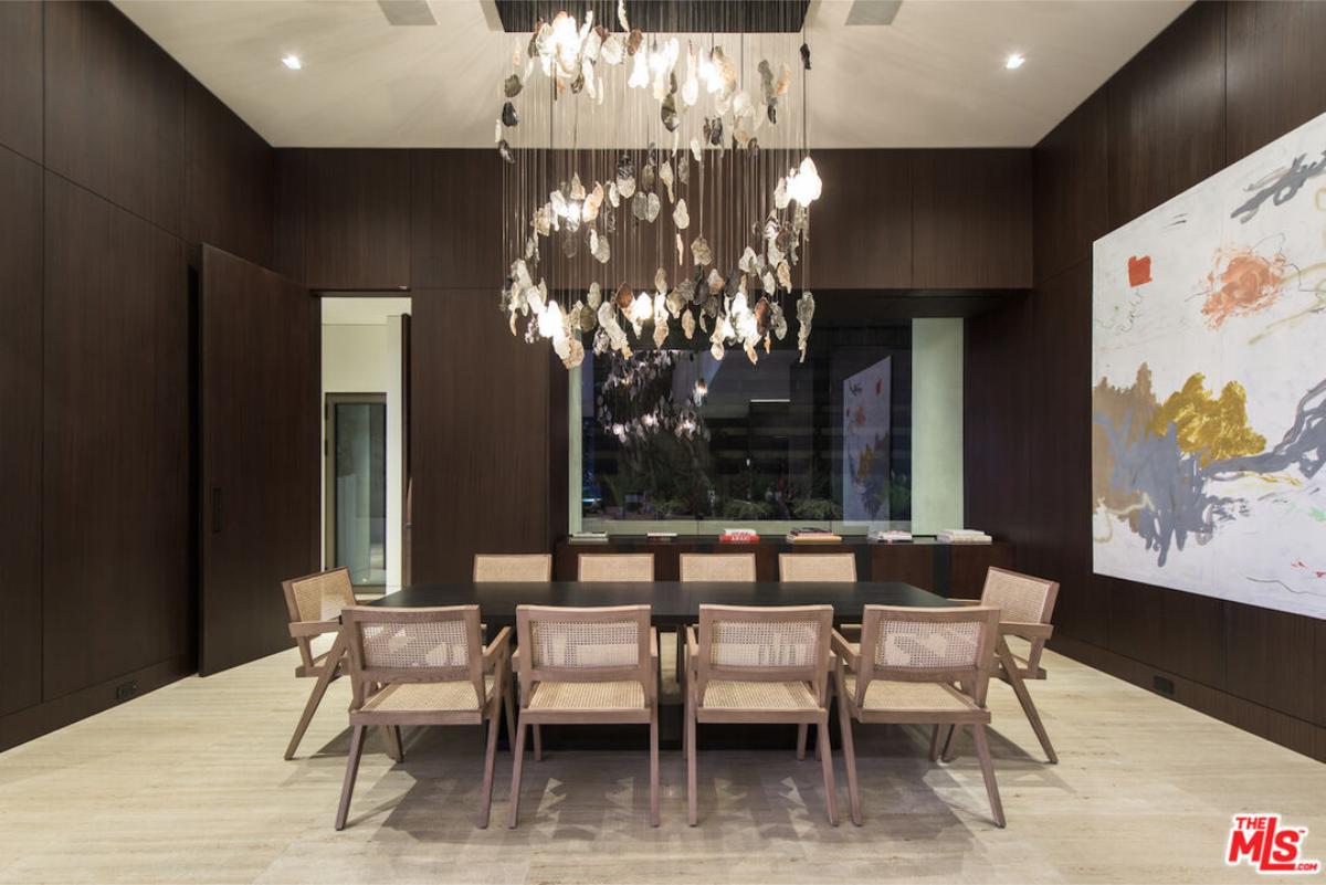 Dining room with a wood table and a chandelier.