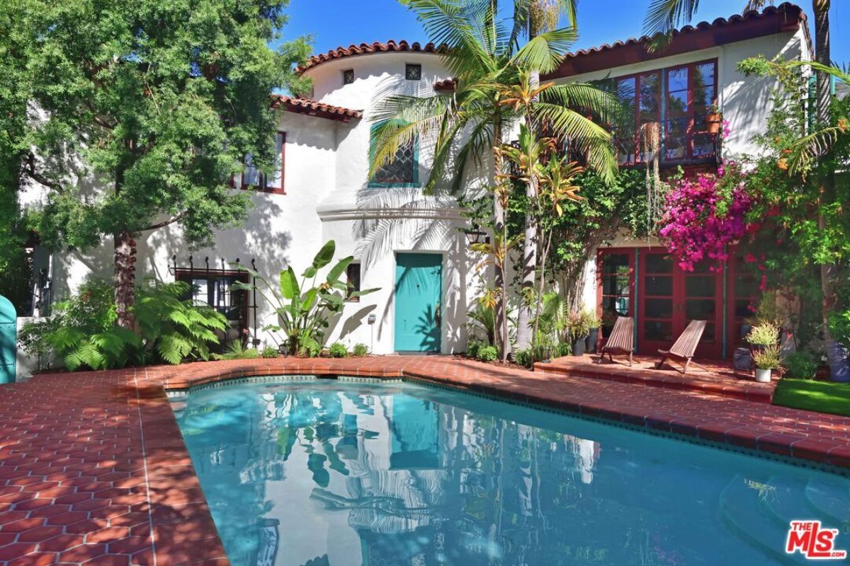 A swimming pool surrounded by plants and trees.