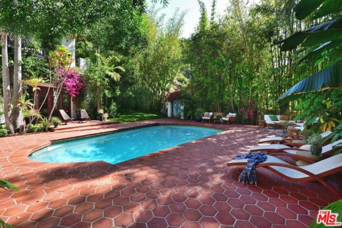 A swimming pool surrounded by plants and trees.