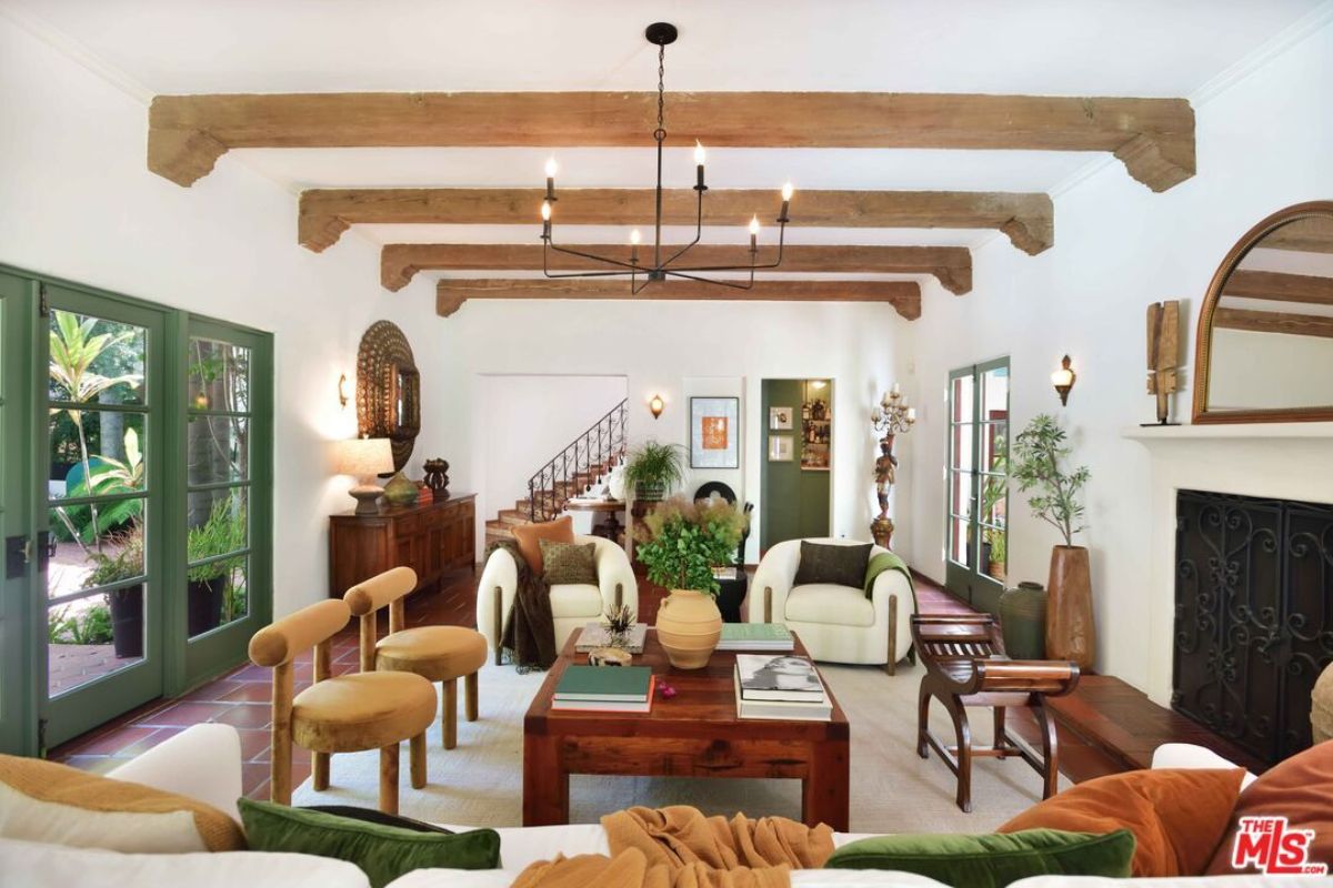 A living room with an exposed beam ceiling, couches, chairs, and a center table.