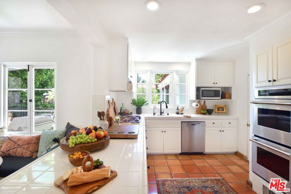 A kitchen with countertops, sink, cabinets, and kitchen appliances.