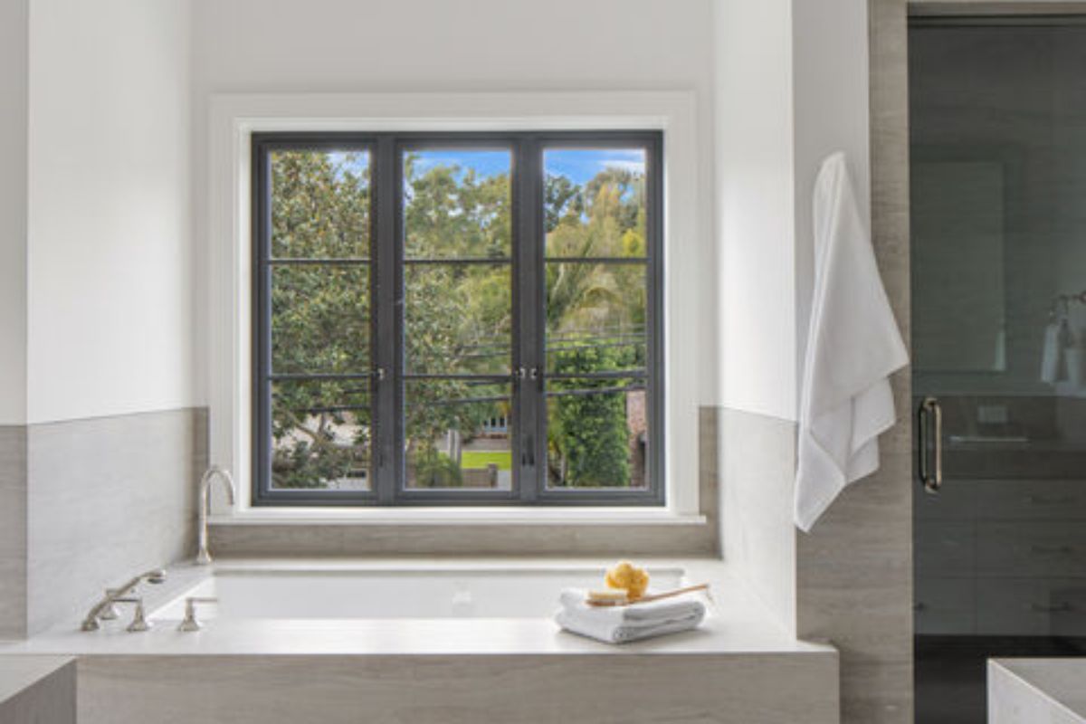 A bathroom with a window and a bathtub.