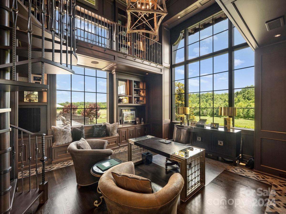 Home office with hardwood flooring, glass windows and couches.