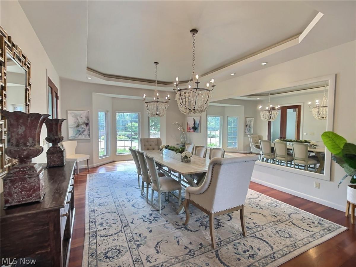 Dining room with chandeliers and a large wood table.