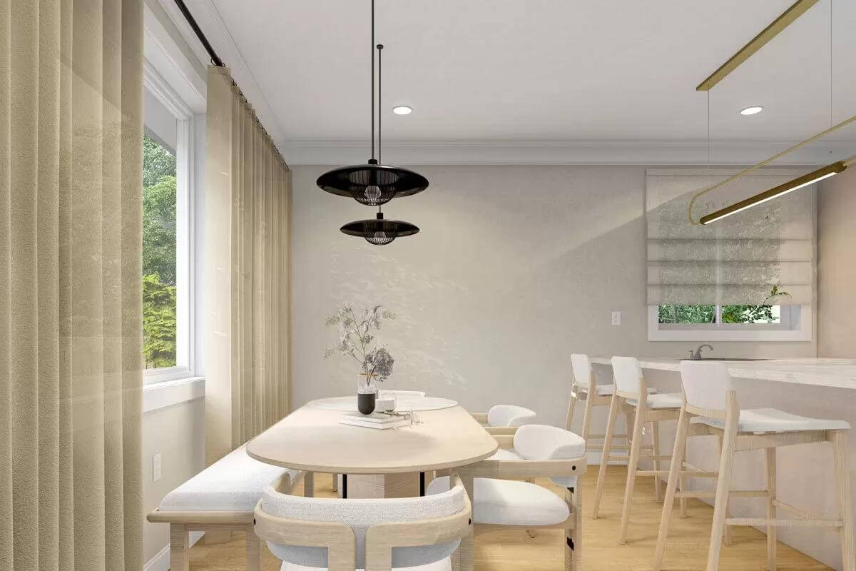 Dining area with an oval dining set topped by wrought iron pendants.