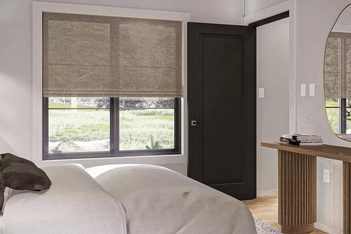 Bedroom with sliding windows and a wooden console table adorned by a brass mirror.