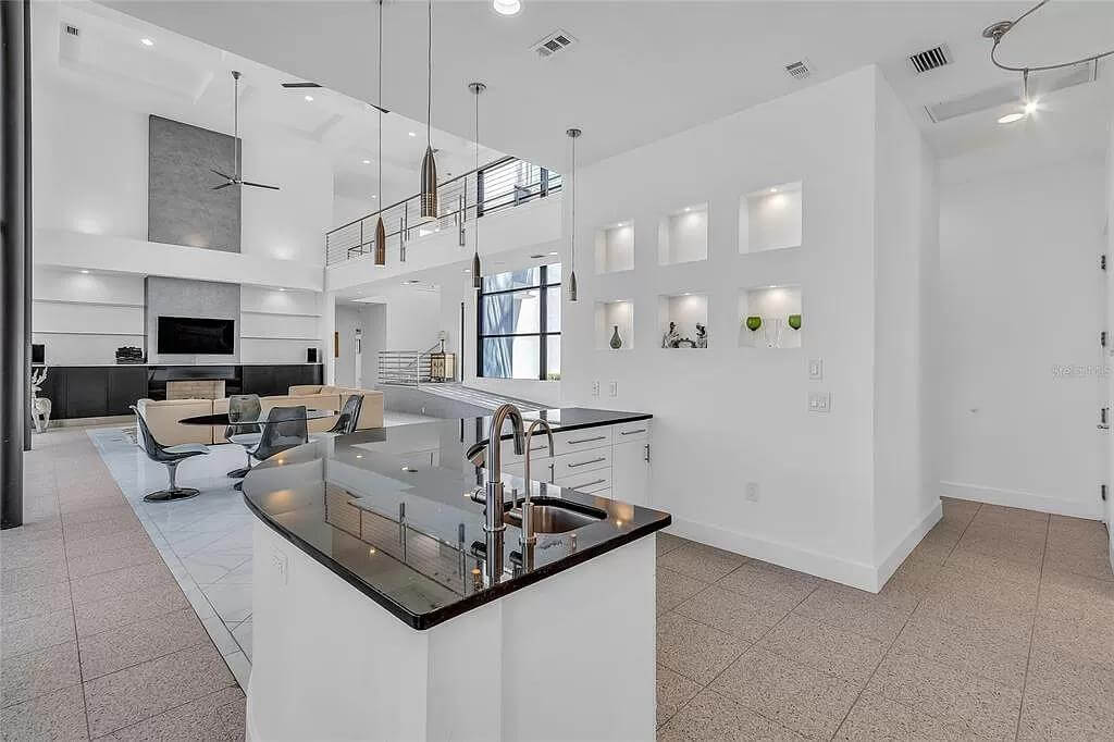 Kitchen and living room surrounded by pristine white walls.