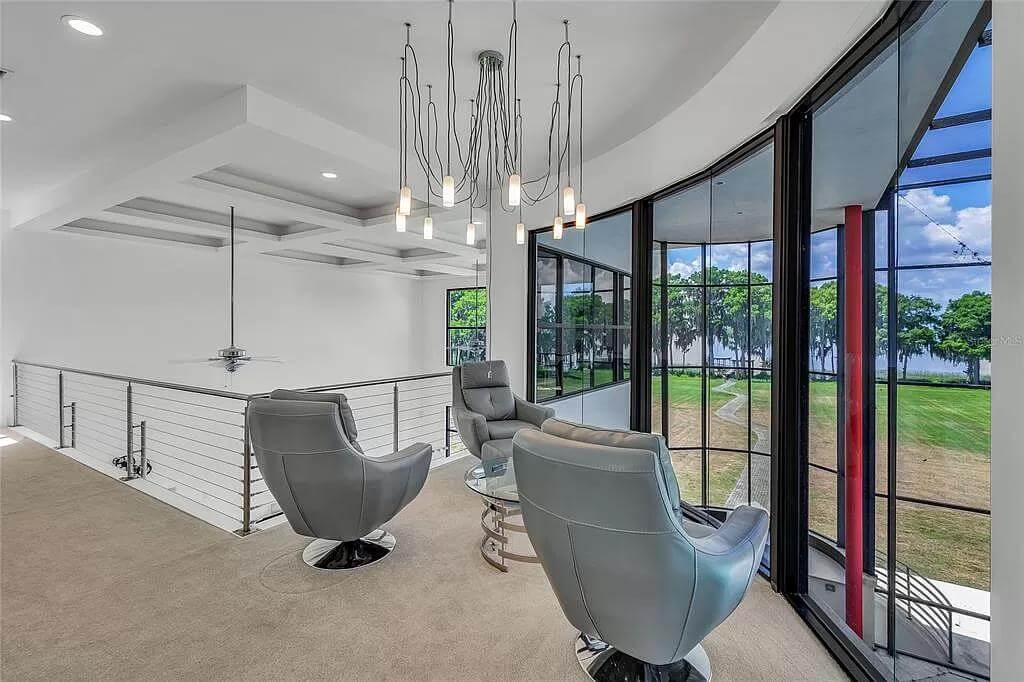 Loft with leather chairs and floor-to-ceiling windows.