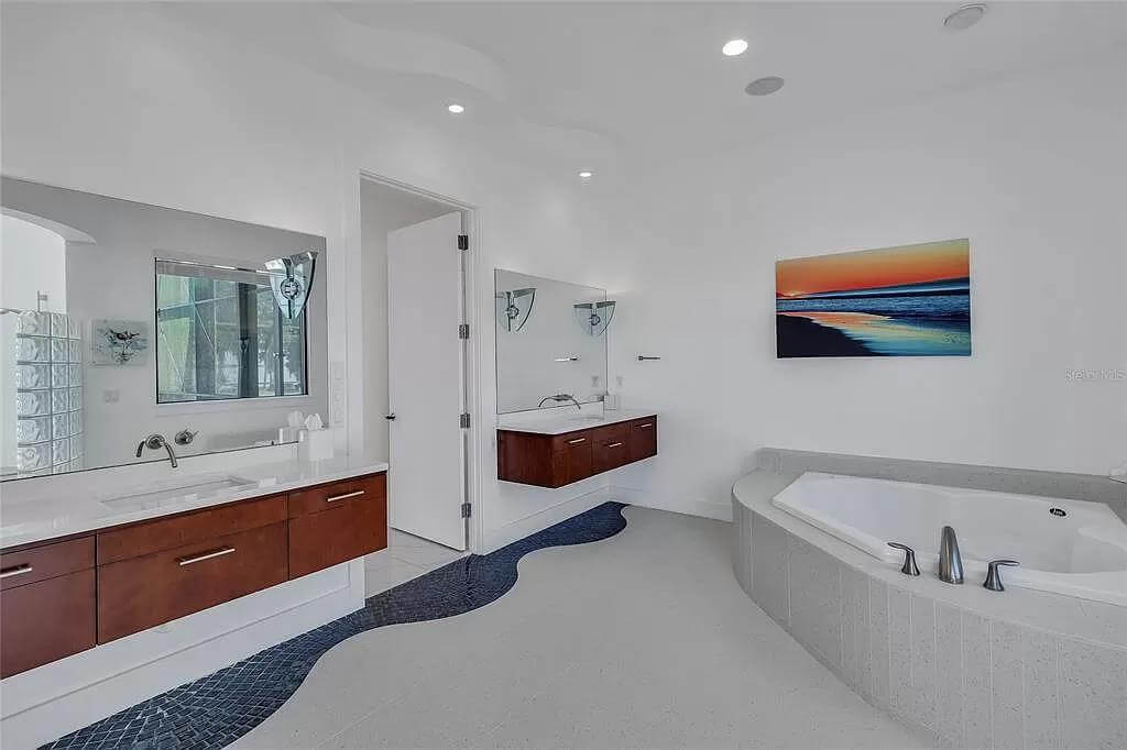 The primary bathroom includes floating vanities paired with frameless mirrors.