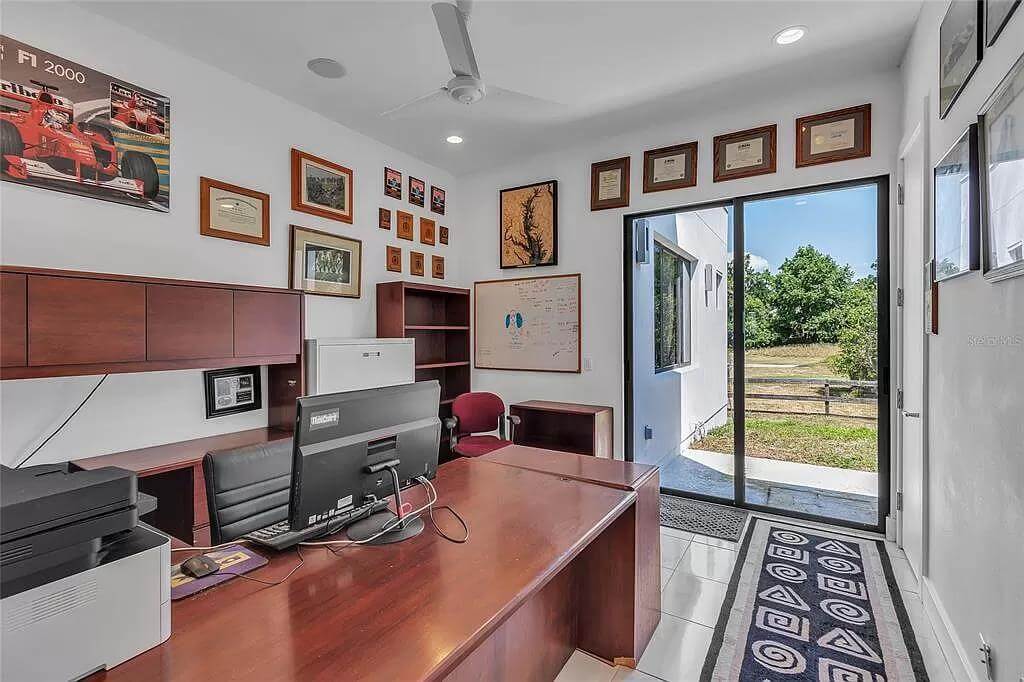 Office with a dark wood des and outdoor access via sliding glass doors.