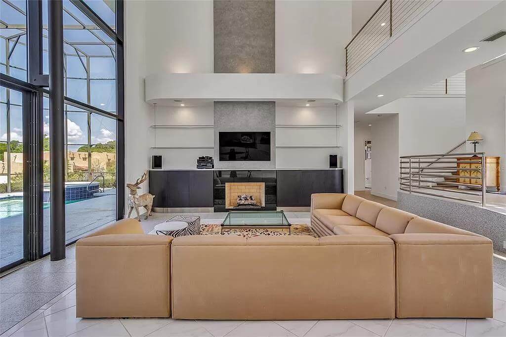 Living room with an L-shaped sofa and a fireplace with a TV on top.