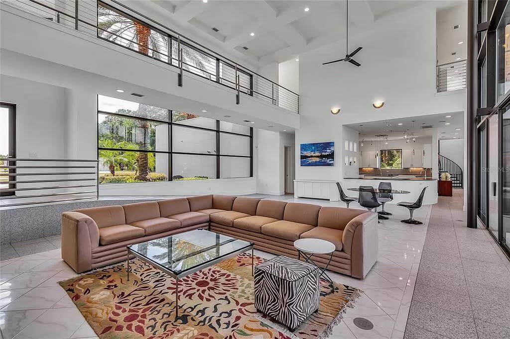 The living room includes a glass-top coffee table and a zebra stool over the printed area rug.