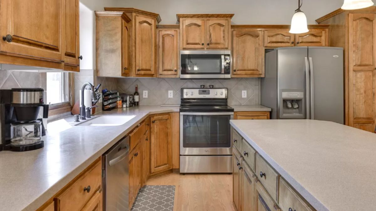 A kitchen with countertops, a sink, cabinets, and kitchen appliances.