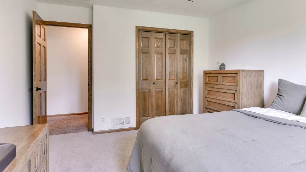 A bedroom with a bed and a cabinet.