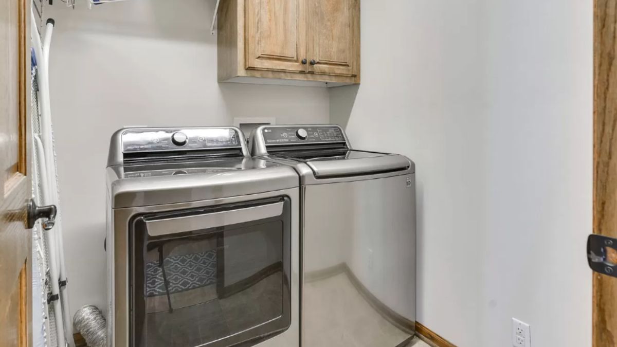 A laundry room with cabinets and washing machines.