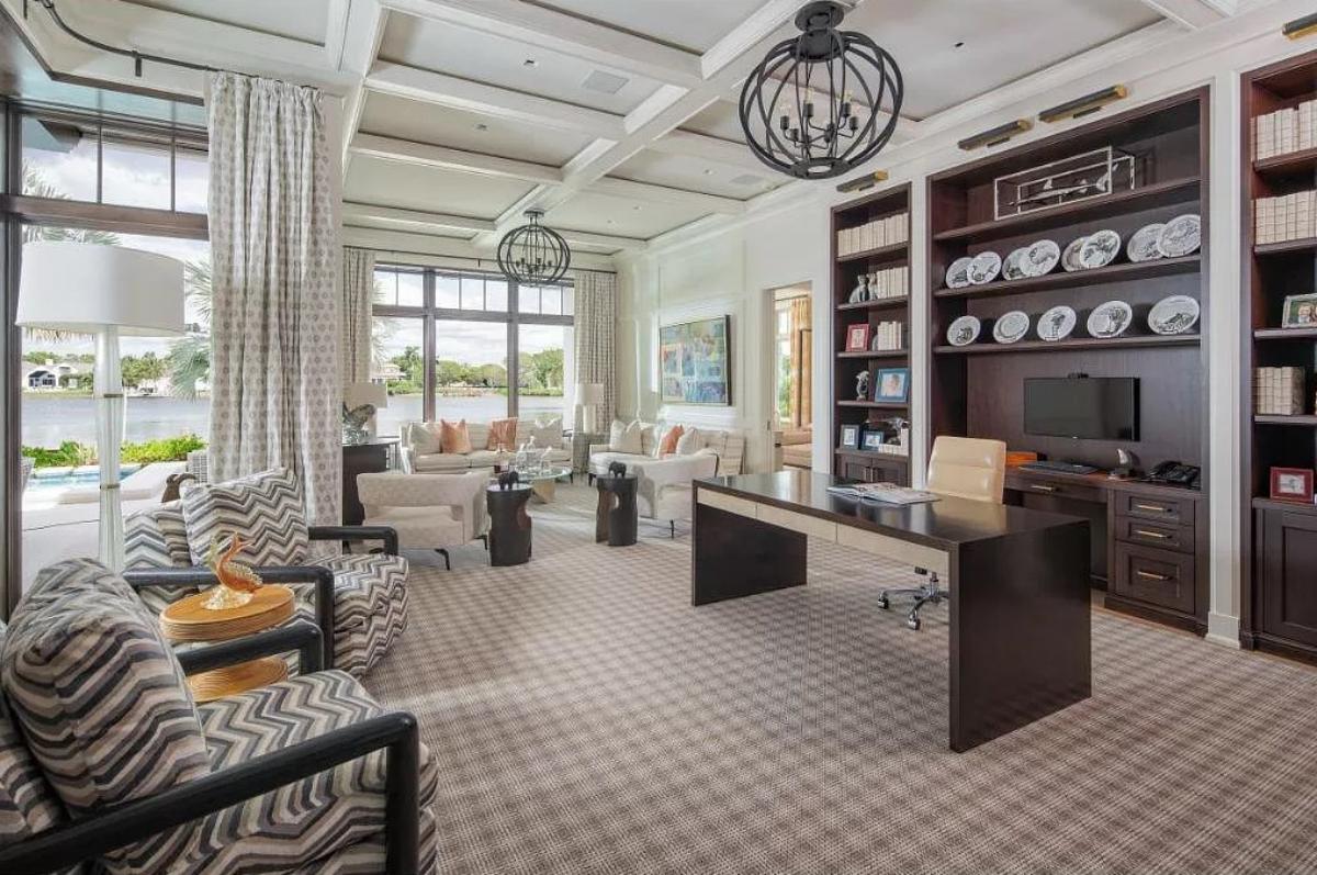 Home office with carpet flooring and coffered ceiling.