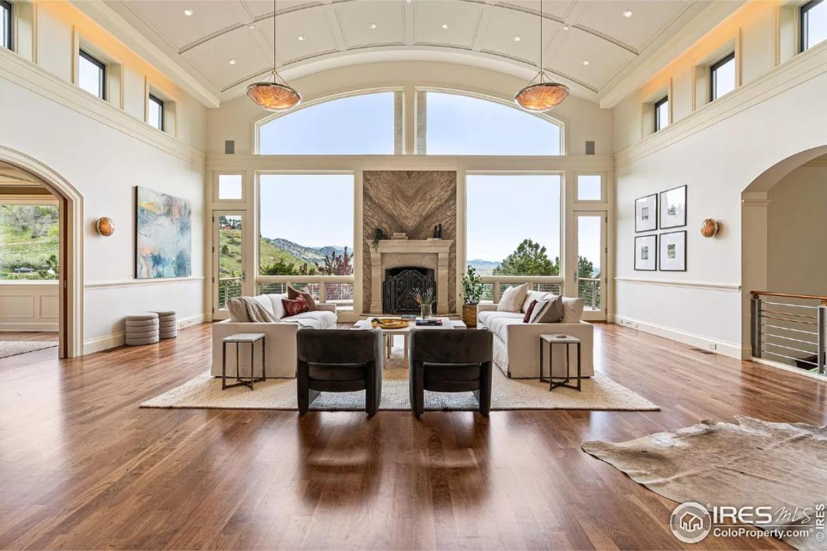 Living room with hardwood floors, glass walls and a fireplace.