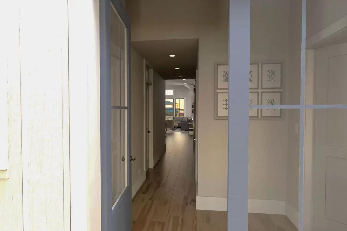 Entry with a glazed front door and white walls adorned by framed artworks.