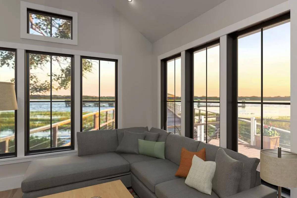 Living room with an L-shaped sectional brightened by black-framed windows.