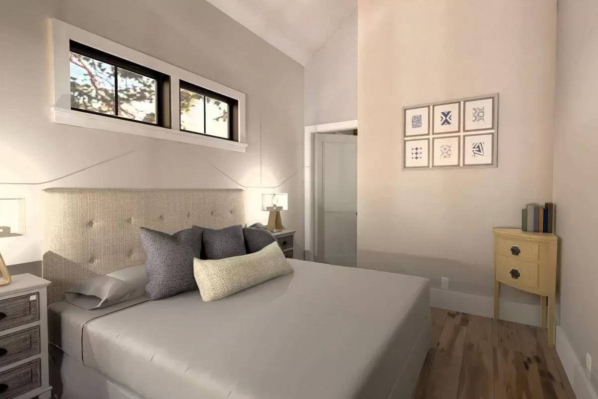 Primary bedroom with a tufted bed topped by clerestory windows.