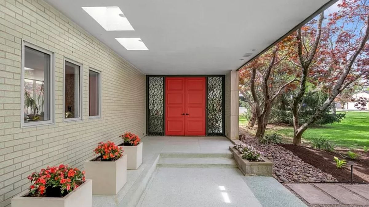 A front entry with plants and a red door.