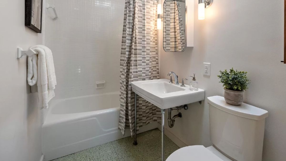 A bathroom with a vanity, toilet, and bathtub.