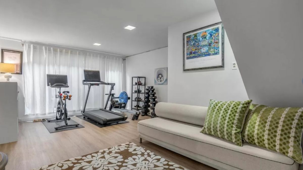 A home gym with a couch and gym equipment.