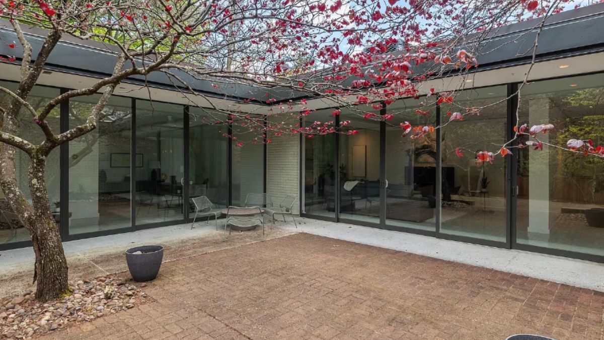 A courtyard with a brick floor and a tree.