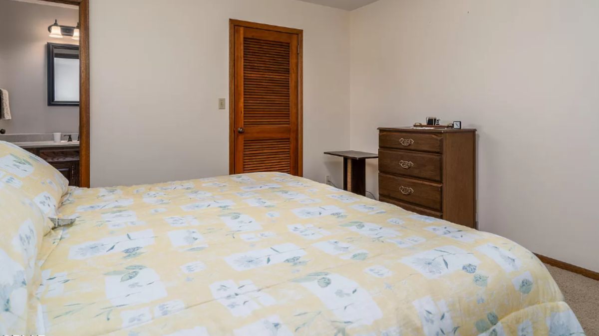 A bedroom with a bed and a cabinet.