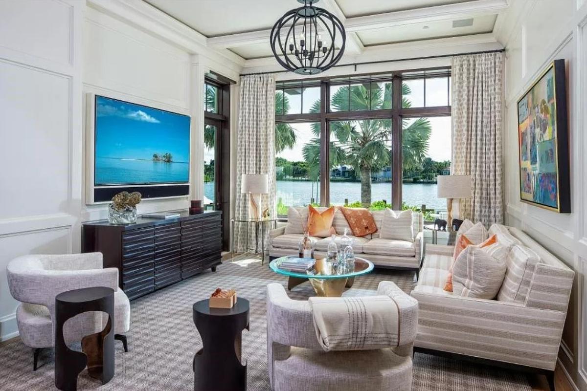 Living room with glass windows, carpet flooring and coffered ceiling.