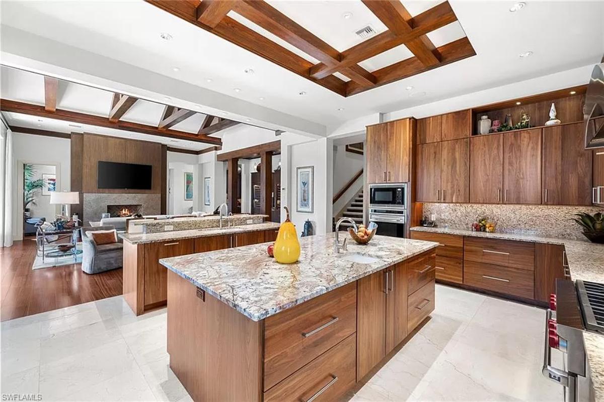 Kitchen with a spacious granite counter breakfast bar and a center island prep area.