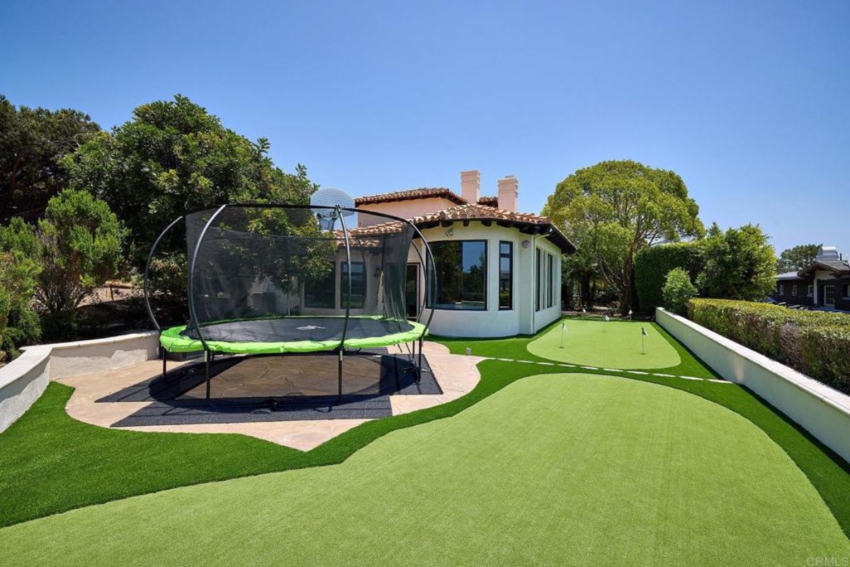 The property features a backyard with a mini golf course and trampoline.