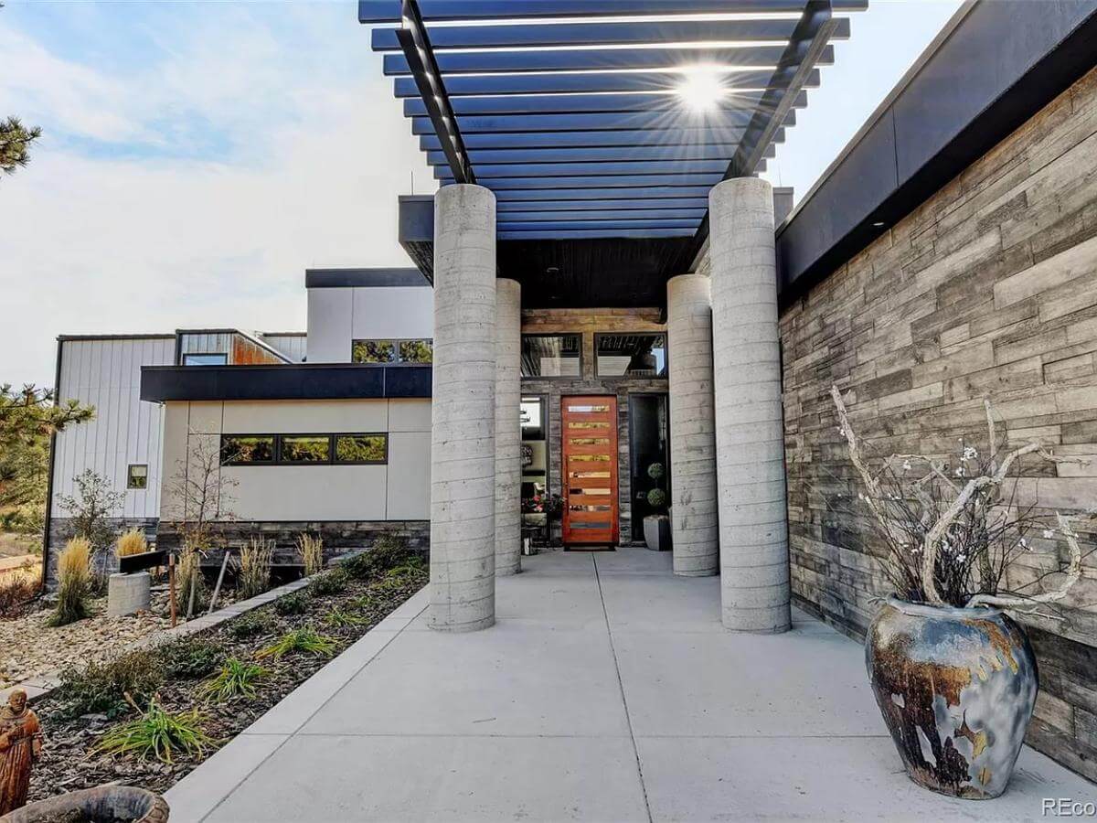 Front entry with huge round pillars and a glazed front door.