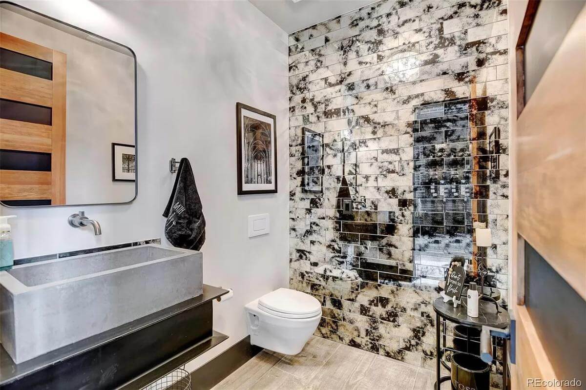 Powder room with a floating washstand and a brick accent wall.